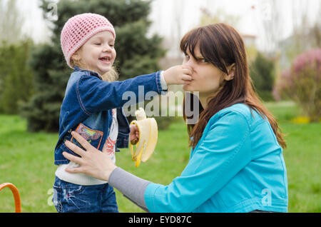 Jeune fille et d'un enfant de trois ans à un pique-nique sur une pelouse verte Banque D'Images