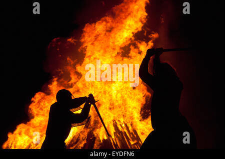 Silhouette d'hommes habillés en soldats Norman en face de grand feu sur la plage, nuit, feu Hastings East Sussex, UK Banque D'Images