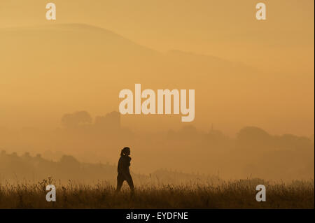 Silhouette d'une femme autour de la ville et du château de Lewes tôt un matin d'automne, Misty, East Sussex, UK Banque D'Images