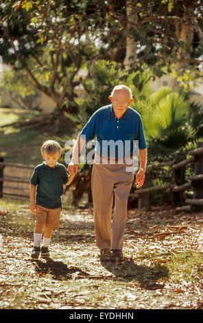 Un homme âgé et son petit-fils âgé de cinq ans marcher ensemble sur un sentier à Lake Forest, CA, sur un après-midi ensoleillé. Banque D'Images