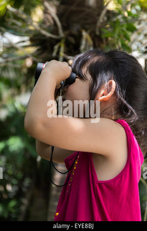 Jolie fille est binoculars lors d'un voyage. Banque D'Images