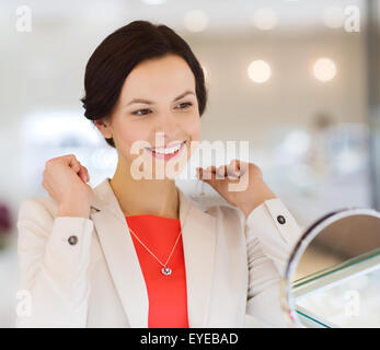 Happy woman choisir au magasin de bijoux pendentif Banque D'Images