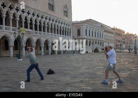 Plier les genoux à l'extérieur des photographes du Palais des Doges, à la Piazza San Marco, Venise, Italie. Banque D'Images