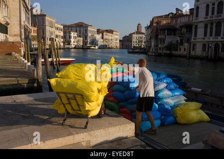 Sacs de fournitures en cours de déchargement d'un bateau sur le Grand Canal, Venise. Banque D'Images