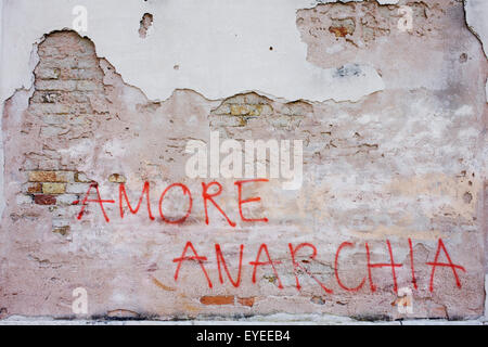 'Amour' anarchie graffiti sur un mur sur un mur sur le Rio de San Margherita canal dans Dorsoduro, un quartier de Venise, Italie. Banque D'Images