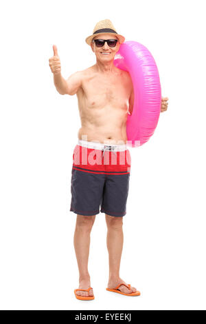 Man slip de bain bleu portant un grand anneau de natation rose et donner un pouce vers le haut isolé sur fond blanc Banque D'Images