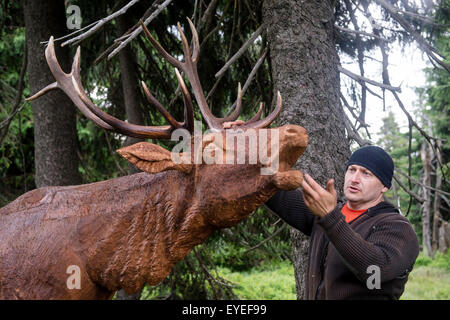 Les touristes qui visitent les Monts des Géants, à la jonction entre la Moravska Bouda et la frontière tchéco-polonaise organise peut voir des sculptures en bois d'animaux en taille réelle. Sur la photo d'une statue d'un cerf à Spindleruv Mlyn, République tchèque, le 28 juillet 2015. (CTK Photo/David Tanecek) Banque D'Images