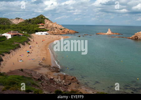 Les touristes du soleil sur la petite plage de sable de Cala Pregonda Menorca Espagne Banque D'Images