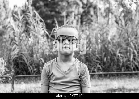 Cheveux courts cute boy wearing sunglasses B&W photo Banque D'Images