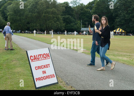 Village d'Ebernoe commune et réserve naturelle. Une route traverse le commun, les conducteurs de voiture sont avertis mise en garde Cricket en cours. Un couple mangeant de la crème glacée profite du match annuel de cricket de la St Jame (25 juillet) Horn Fair. Ebernoe CC versus Wessex Pilgrims CC. Ebernoe, West Sussex 2017 Angleterre 2010s UK HOMER SYKES Banque D'Images