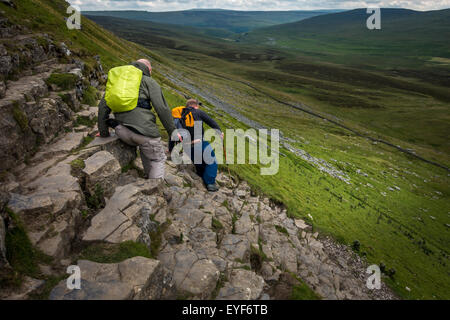 Deux personnes soigneusement en ordre décroissant de la section escarpées et rocheuses de Pen-y-ghent dans le Yorkshire Dales, partie de la Pennine Way, UK Banque D'Images