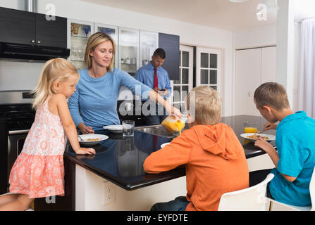 Les parents avec enfants (8-9, 10-11) et sa fille (2-3) pendant le petit déjeuner Banque D'Images