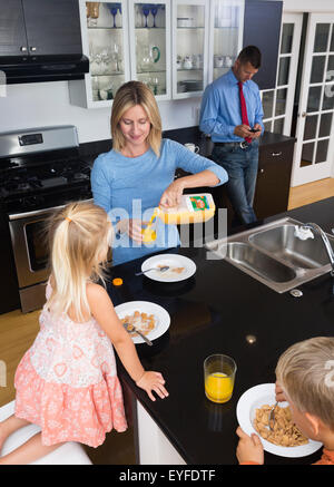 Les parents avec sa fille (2-3) et son (8-9) pendant le petit déjeuner Banque D'Images