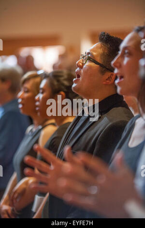 Un prêtre Américain asiatique chante avec les membres de la congrégation à une Laguna Niguel, CA, l'Église catholique au cours des cérémonies de confirmation. La confirmation est l'un des sept sacrements par lesquels les catholiques passent dans le processus de leur éducation religieuse. Banque D'Images