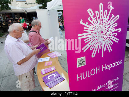 Zagreb, Croatie. 28 juillet, 2015. Les gens lisent des dépliants au cours d'une manifestation pour marquer la Journée mondiale de l'hépatite à Zagreb, capitale de la Croatie, le 28 juillet 2015. © Lisanin Miso/Xinhua/Alamy Live News Banque D'Images