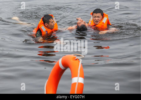 Dalian, province de Liaoning en Chine. 29 juillet, 2015. Les garde-côtes sauver un homme de l'eau dans un forage de sauvetage maritime à Dalian, Liaoning Province du nord-est de la Chine, le 29 juillet 2015. © Gui Ziyun/Xinhua/Alamy Live News Banque D'Images