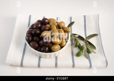 Olives vertes et noires sur une plaque avec une serviette sur la direction générale de l'olivier Banque D'Images