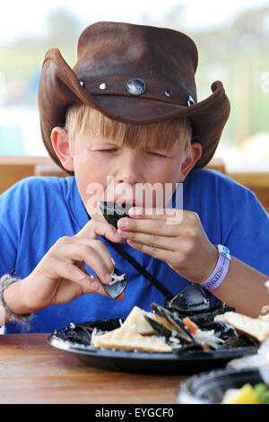 Saint Petersburg, Floride, garçon avec chapeau de cowboy de manger des moules fraîches Banque D'Images