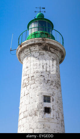 Typique des côtes de la mer Méditerranée vieux phare sur fond de ciel bleu. White tour ronde en pierre avec partie supérieure verte Banque D'Images