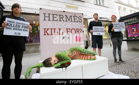 Berlin, Allemagne. 29 juillet, 2015. Les membres du groupe de défense des droits des animaux Peta manifestation devant un magasin de la marque Hermes contre l'assassinat de crocodiles pour les sacs en cuir de luxe à Berlin, Allemagne, 29 juillet 2015. Un modèle, peint avec de la peau de crocodile artificiel, se trouve dans un faux mare de sang sur le Kurfürstendamm à Berlin. Dpa : Crédit photo alliance/Alamy Live News Banque D'Images