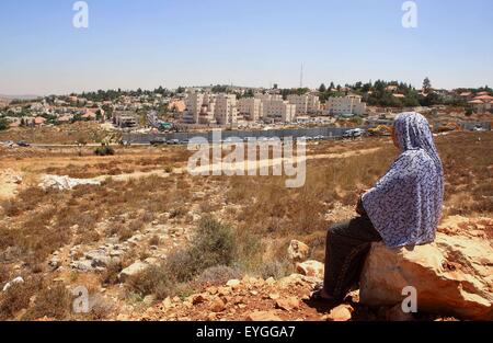 28 juillet 2015 - Ramallah, Cisjordanie, territoire palestinien - une femme palestinienne, israélienne montres de la machinerie lourde comme ils démolir blocs appartement vacant par ordre de la haute cour d'Israël en Cisjordanie, colonie juive de Beit El, près de Ramallah, le 29 juillet 2015. Israël a donné son approbation finale le mercredi pour des plans pour construire 300 nouveaux logements dans la colonie juive en Cisjordanie occupée, annonce le déménagement comme il a effectué un ordre de démolition de la cour contre deux blocs appartement vacant sur le site. Des dizaines de colons juifs se sont réunis au cours de ces derniers jours à la colonie de Beit El à protester ag Banque D'Images