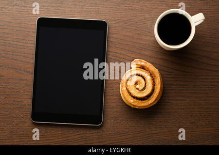 La cannelle, tasse de café et l'ordinateur tablette. Petit-déjeuner d'affaires. Banque D'Images