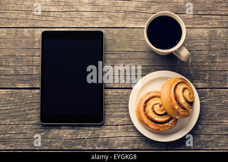 La cannelle, tasse de café et l'ordinateur tablette. Petit-déjeuner d'affaires. Banque D'Images
