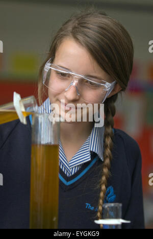 Élève du secondaire menant à l'expérience d'une leçon de science, Surrey, UK. Banque D'Images