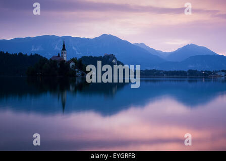 Le lever du soleil sur le lac de Bled et l'église de l'île de l'assomption de Marie avec le massif des Karavanke montagnes en arrière-plan, la Slovénie. Banque D'Images