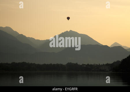Un ballon à air chaud s'élève au-dessus de la montagne derrière le lac de Bled, en Slovénie. Banque D'Images