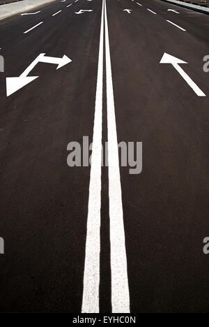 Le marquage routier sous la forme de flèches sur la route asphaltée dans la ville Banque D'Images