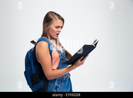 Choqué young woman reading book isolé sur fond blanc Banque D'Images