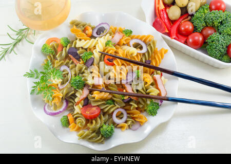 Repas de macaroni pâtes aux légumes cuits avec des légumes frais servis avec des baguettes et un verre de vin Banque D'Images