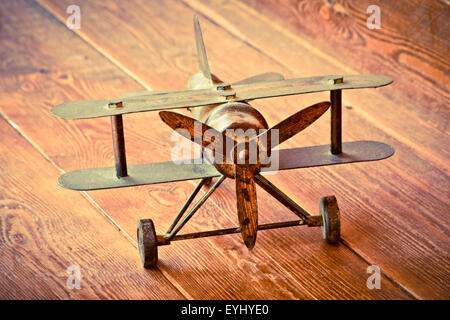 Avion métallique miniature sur surface en bois. Banque D'Images