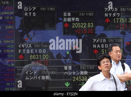 Tokyo, Japon. 30 juillet, 2015. Montres homme se tient le tableau électrique l'affichage des stocks sur un tableau électrique le 30 juillet 2015 à Tokyo, au Japon, le Nikkei Stock Average est passé à 20522 yen par 1.1 où Chinois a de nouveau chuté. © Koichi Kamoshida/Jana Press/Zuma Zuma/fil Wire/Alamy Live News Banque D'Images