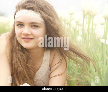 Adolescente, le champ de tulipes en portant une belle robe blanche et headband Banque D'Images