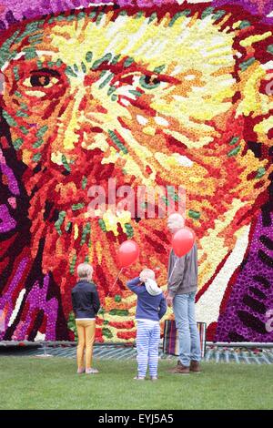 (150730) -- Amsterdam, 30 juillet 2015 (Xinhua) -- les gens regardent un tableau de fleurs représentant le célèbre peintre hollandais Vincent van Gogh, au Museumplein à Amsterdam, Pays-Bas, le 30 juillet 2015. Le 8 mètre de haut, autoportrait de Vincent van Gogh, faite de 50 000 dahlias, a été construit sur le 29 juillet à l'occasion du 125e anniversaire de sa mort à Auvers-sur-Oise, France. (Xinhua/Sylvia Lederer) Banque D'Images