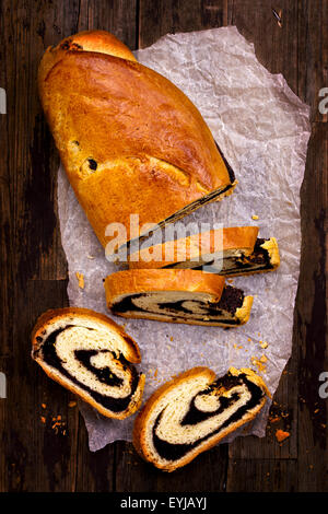 Couper le gâteau aux graines de pavot en plongée des sur fond de bois Banque D'Images