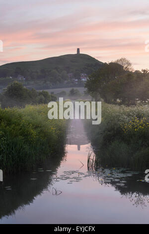 Mist suaires Glastonbury Tor pendant un printemps coloré lever de soleil sur le Somerset Levels. Banque D'Images