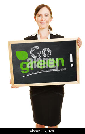 Business Woman holding 'go green' concept sur un tableau noir dans ses mains Banque D'Images