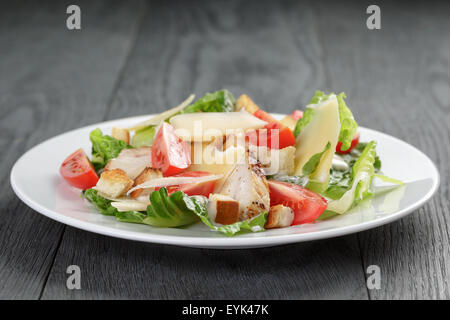 Salade césar avec poulet sur table en chêne Banque D'Images