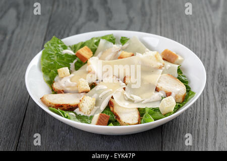 Salade césar avec poulet sur table en chêne Banque D'Images