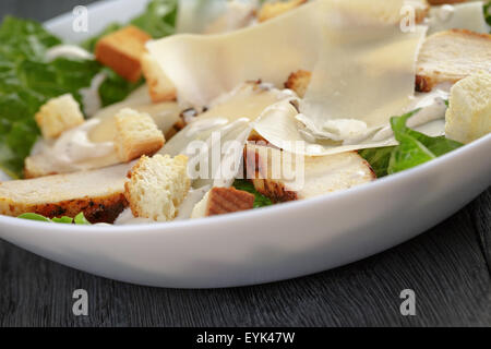 Salade césar avec poulet sur table en chêne Banque D'Images