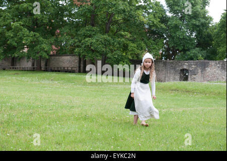Une petite fille en costume médiéval au château médiéval de Cesis en Lettonie. Banque D'Images