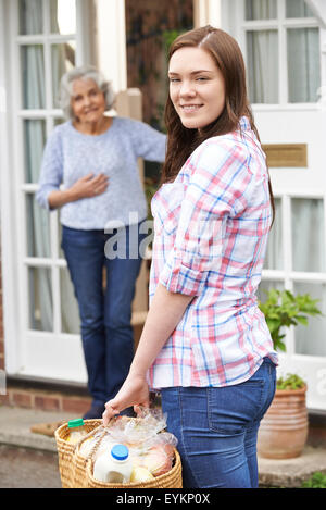 Teenage Girl Doing Shopping pour Senior Woman Banque D'Images