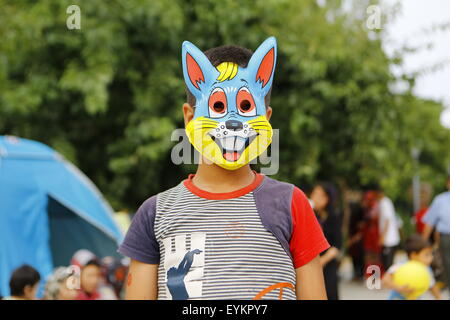 Athènes, Grèce. Le 31 juillet 2015. Un garçon Afghan porte un masque de lapin fantaisie dans le camp de réfugiés de fortune Pedion tou Areos à Athènes. Les réfugiés afghans qui sont arrivés à Athènes via les îles grecques se sont installés depuis plus d'une semaine dans le centre du parc Pedion tou Areos à Athènes, avec l'aide d'organismes bénévoles qui fournissent de la nourriture, des vêtements et des soins médicaux aux réfugiés. Crédit : Michael Debets/Alamy Live News Banque D'Images