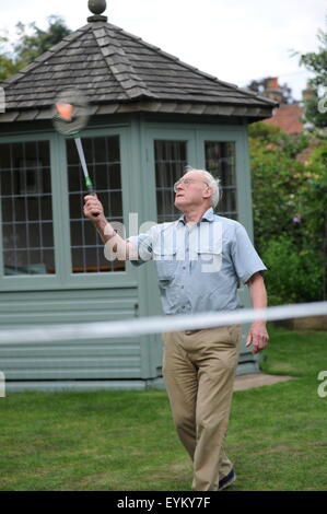Personnes âgées grand-père jouer au badminton avec son petit-fils dans le jardin de la famille dans le Nord du Yorkshire, UK Banque D'Images