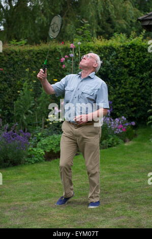 Personnes âgées grand-père jouer au badminton avec son petit-fils dans le jardin de la famille dans le Nord du Yorkshire, UK Banque D'Images