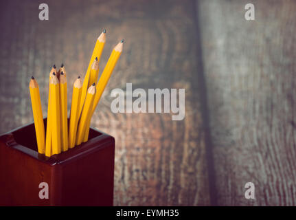 Groupe des crayons jaunes en porte-crayons. Vintage background with copy space. Focus sélectif. Banque D'Images