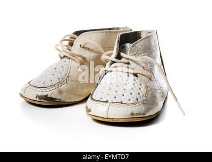 Vieux cuir usé vintage chaussures bébé blanc isolé sur blanc avec des ombres naturelles. Banque D'Images